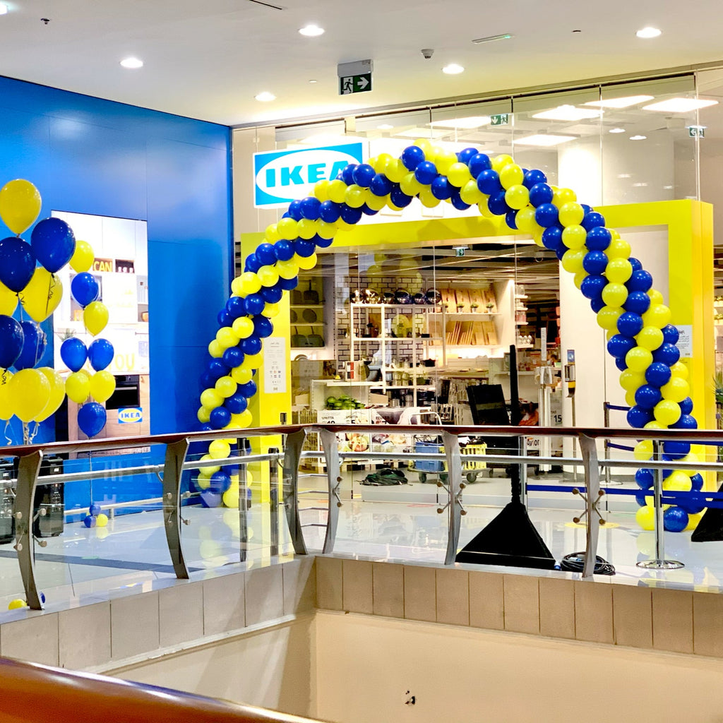 Decorative arch made of balloons with IKEA branding inside a store.