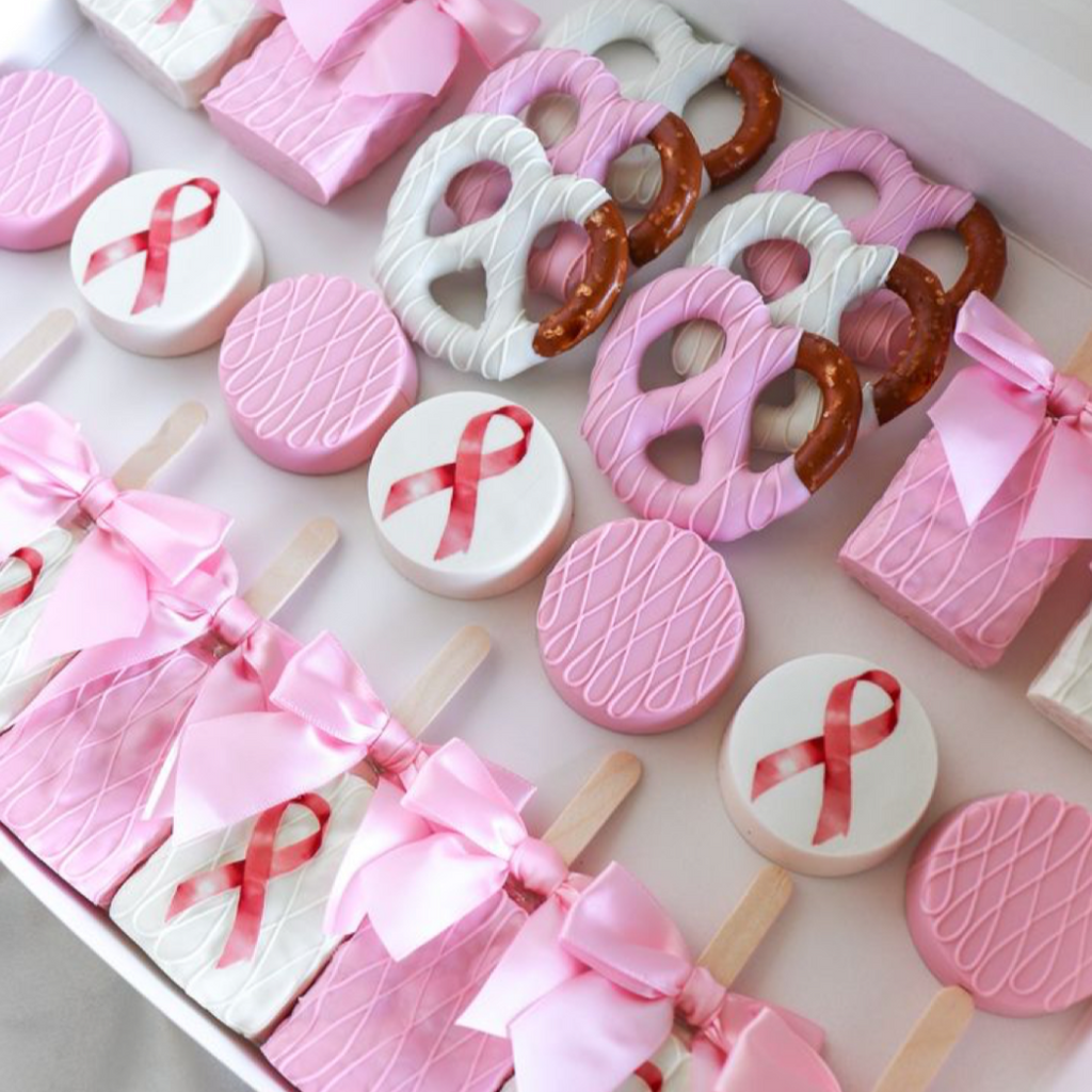 Pink-themed party package with cookies and candies on a white plate.