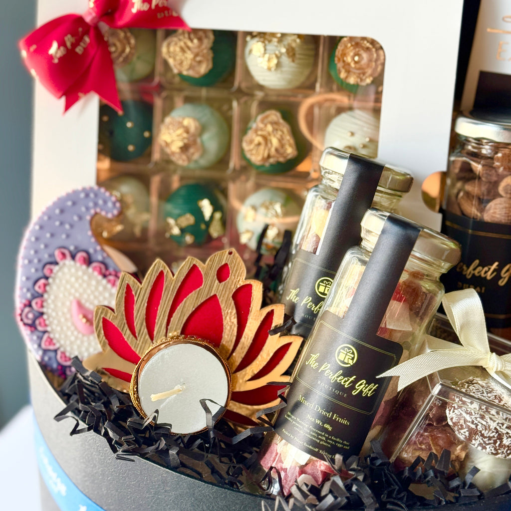 Gift basket with decorative items and a candle, featuring a brand label.
