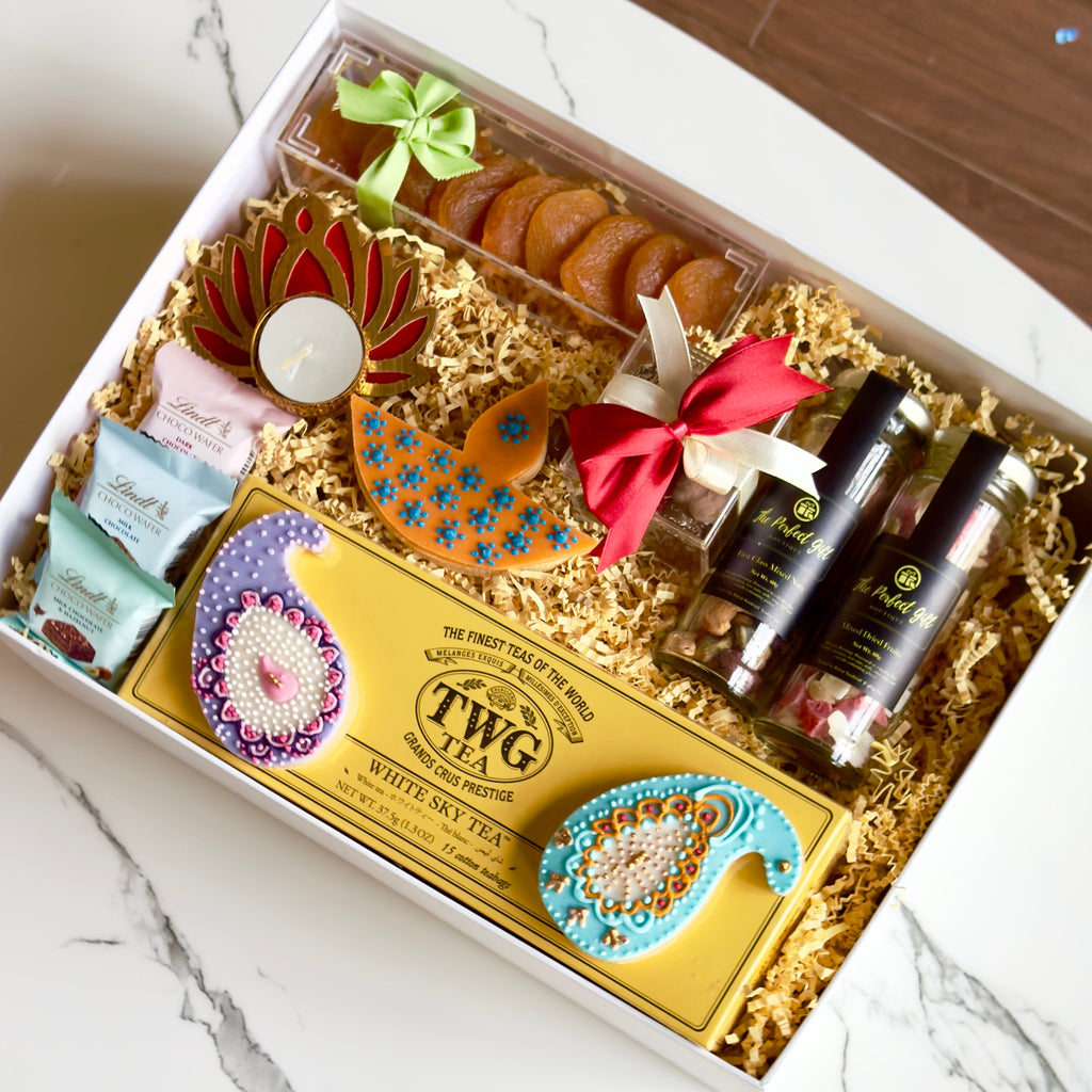 Gift box with TWG tea and cookies on a marble surface