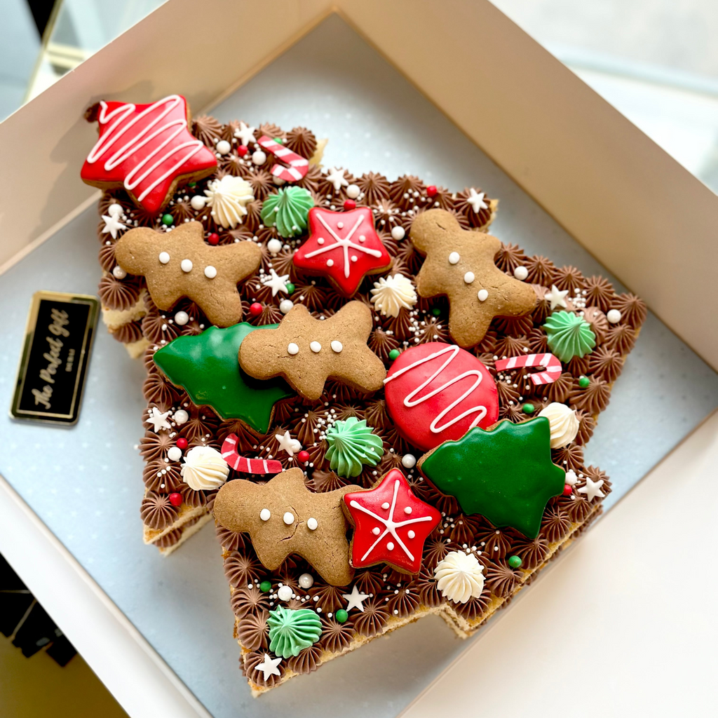 Decorative gingerbread-themed cookie arrangement in a box