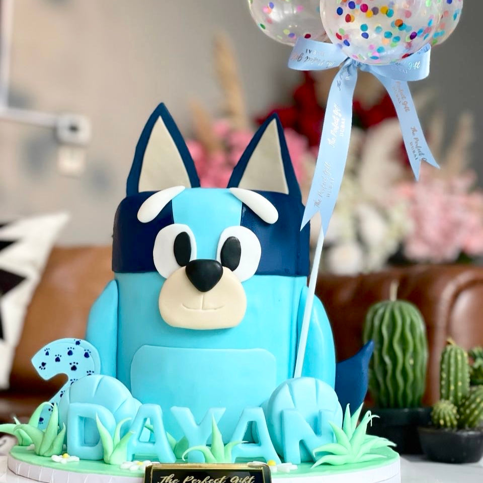 Blue cartoon dog figurine with balloons on a decorative stand