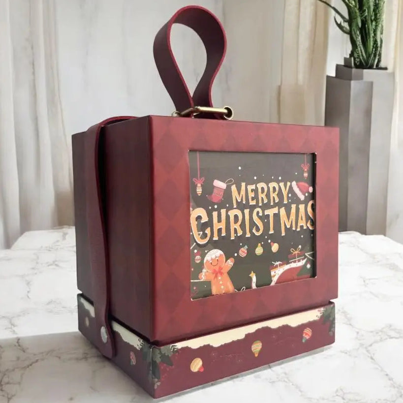 Decorative Christmas box with 'Merry Christmas' text and gingerbread man design on a marble surface.