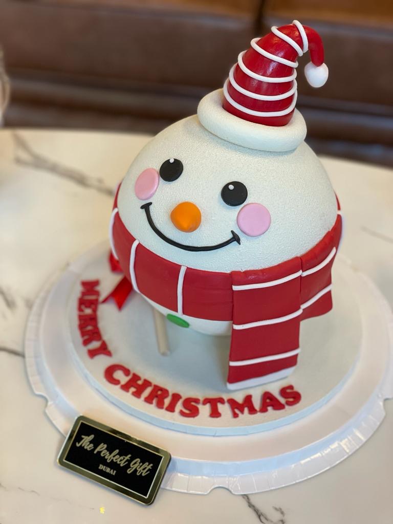 Christmas-themed cake with a snowman design on a marble surface