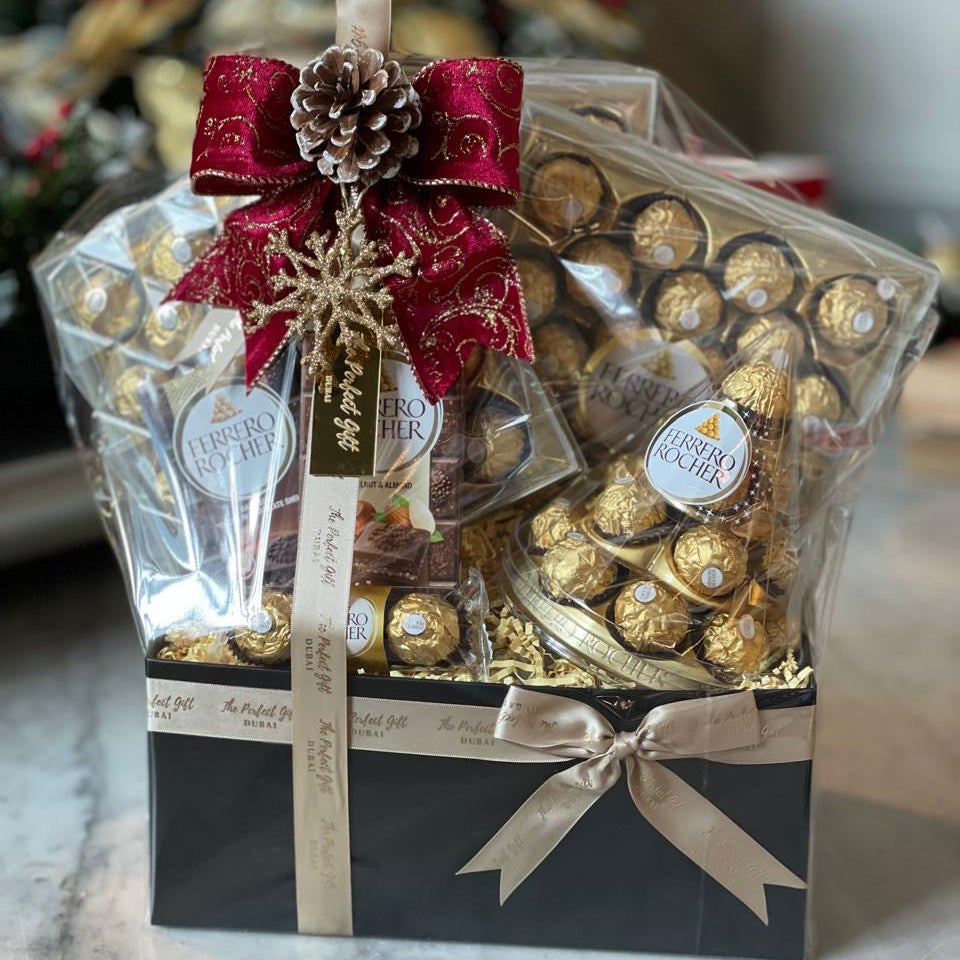 Ferrero Rocher chocolate gift set with decorative ribbons on a marble surface.