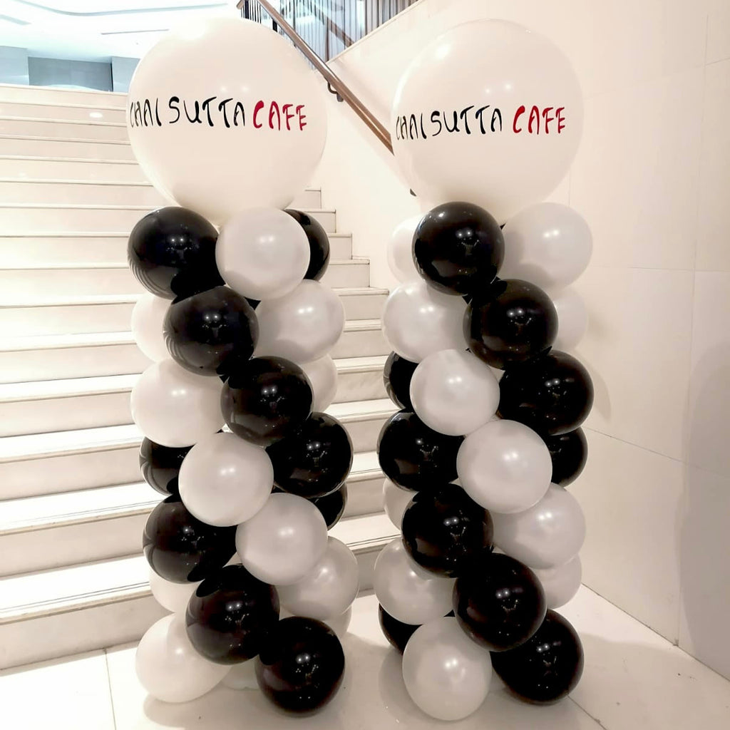 Balloon arch with 'Suitsuca Cafe' branding in a modern indoor setting