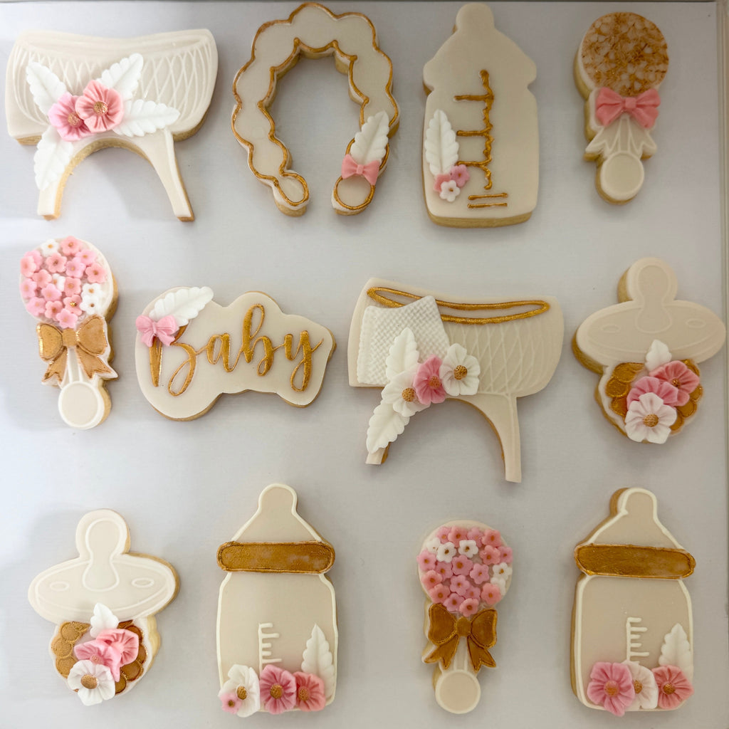 Decorative cookies shaped like baby items on a white background