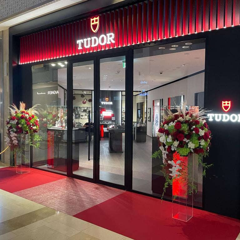 TUDOR watch store entrance with red carpet and floral arrangements