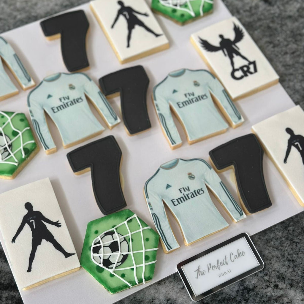 Cookies decorated with soccer-themed designs on a marble surface